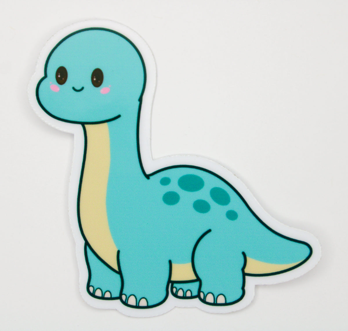 A die-cut sticker featuring a cute, cartoon-style turquoise blue long-necked dinosaur with a cream-colored neck and spots on its back, shown on a plain white background.