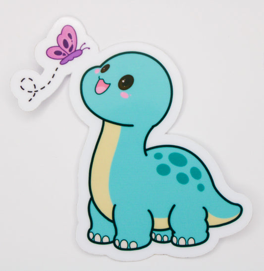 A die-cut sticker featuring a cute light blue long-necked dinosaur with a cream belly, spotted back, and a small pink butterfly on a white background.