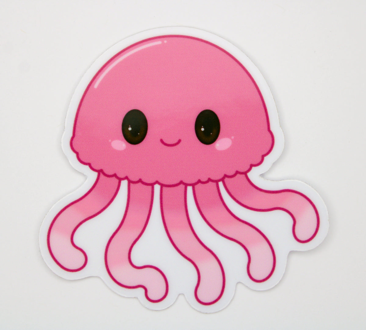 A cute pink cartoon jellyfish sticker with large black eyes and a smiling mouth, shown on a plain light background.