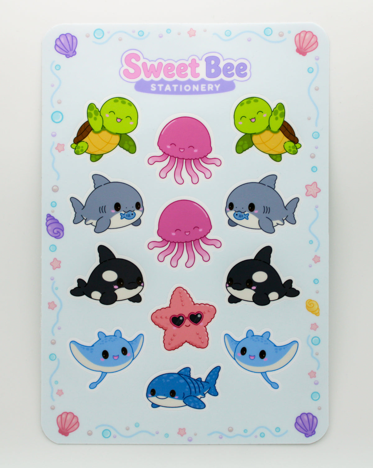 A Sweet Bee Stationery sticker sheet featuring cute cartoon sea creatures including turtles, octopus, dolphins, orcas, a blue shark, a pink starfish, and a blue stingray on a light blue background.
